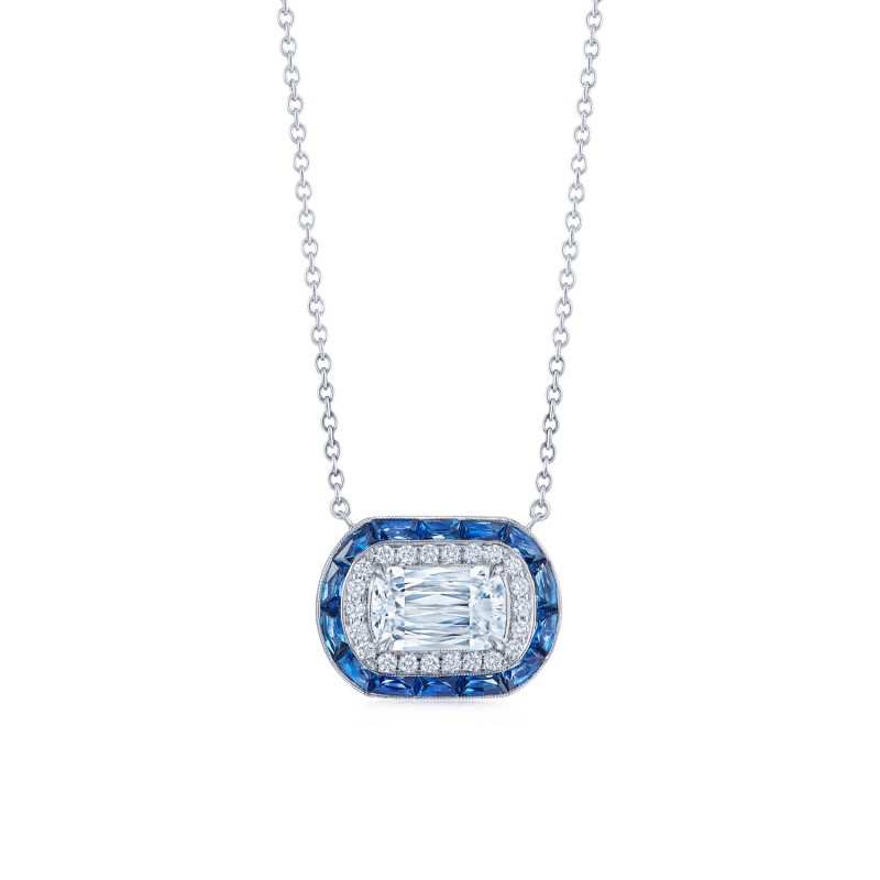 The white gold ASHOKA Diamond and Sapphire Halo Pendant with an ASHOKA diamond centerpiece and a double halo of brilliant round diamonds and baguette-cut sapphires, available at Deutsch Fine Jewelry in Houston, Texas.